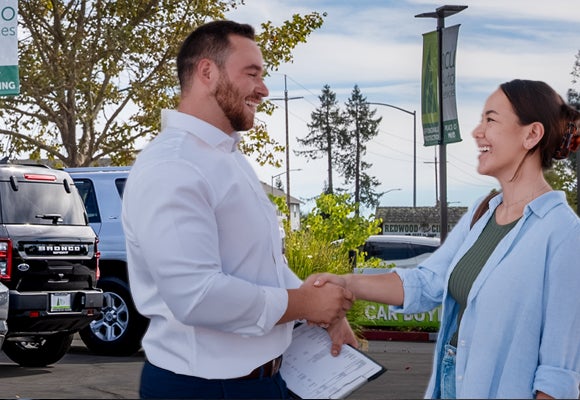 Woman and RCU Auto Services employee shaking hands