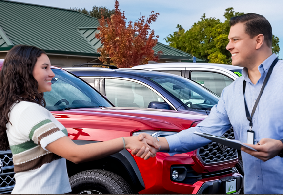 Woman shaking hand of Dealership representitive